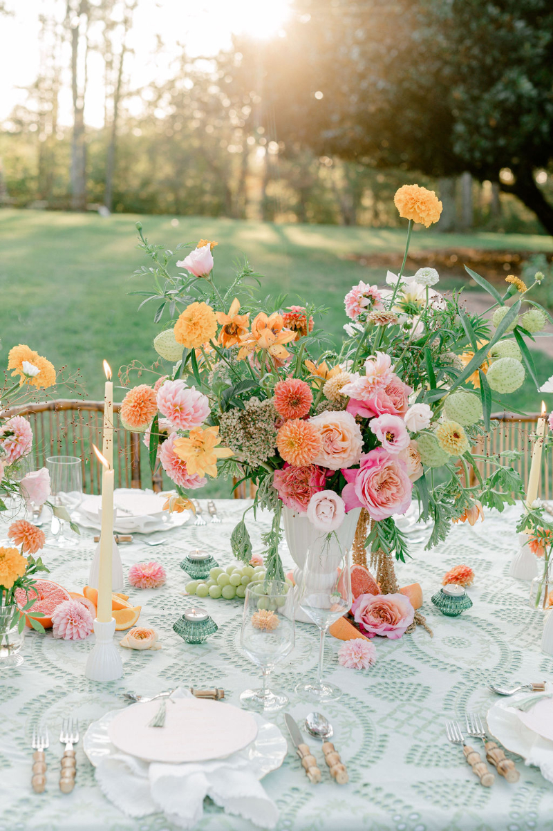 A WEDDING TABLESCAPE WITH CITRUS FLOWER ARRANGEMENTS