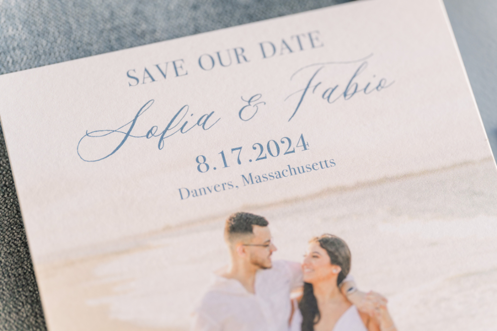 Close-up of a beach-themed save the date card featuring couple Sofia and Fabio with wedding details in soft blue typography.

when to send save the dates
